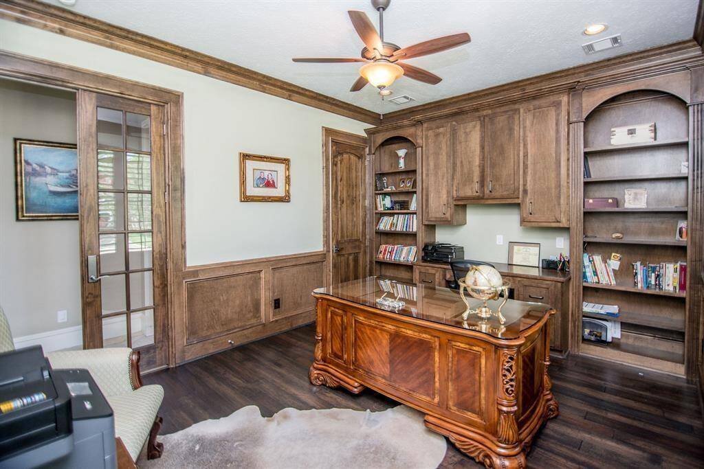Spacious office with elegant wood cabinetry and ample shelving, perfect for a large desk and organized workspace.