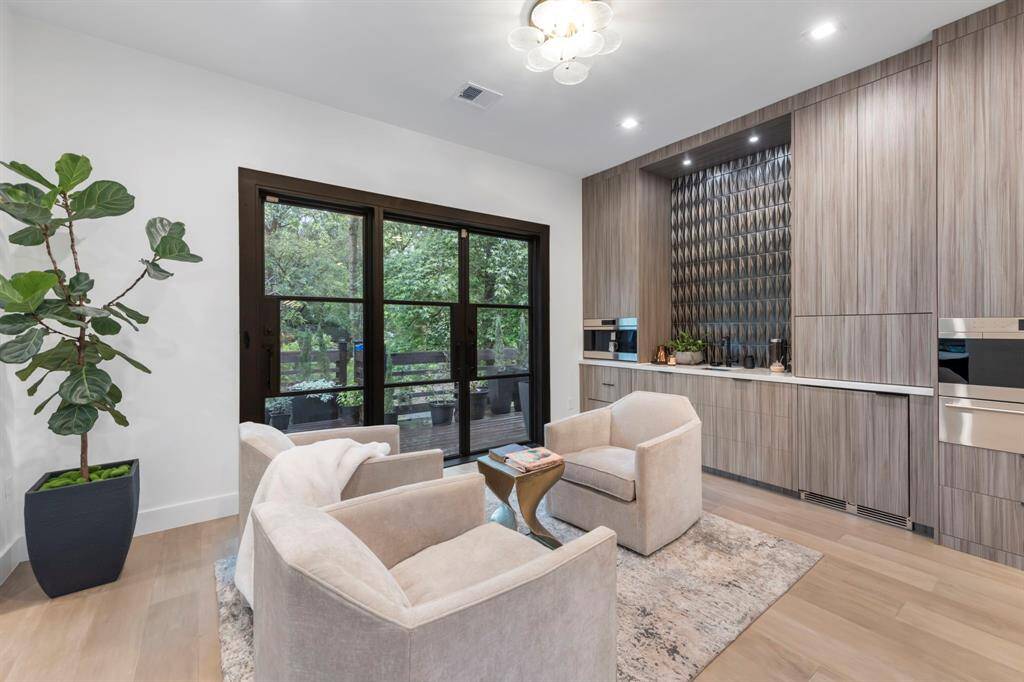 Ample cabinetry, wet bar and modern doors leading out to the balcony for the ultimate indoor/outdoor experience.