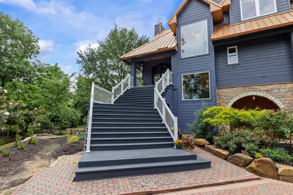 A wide, elegant staircase leads to the entrance of this remodeled custom home.
