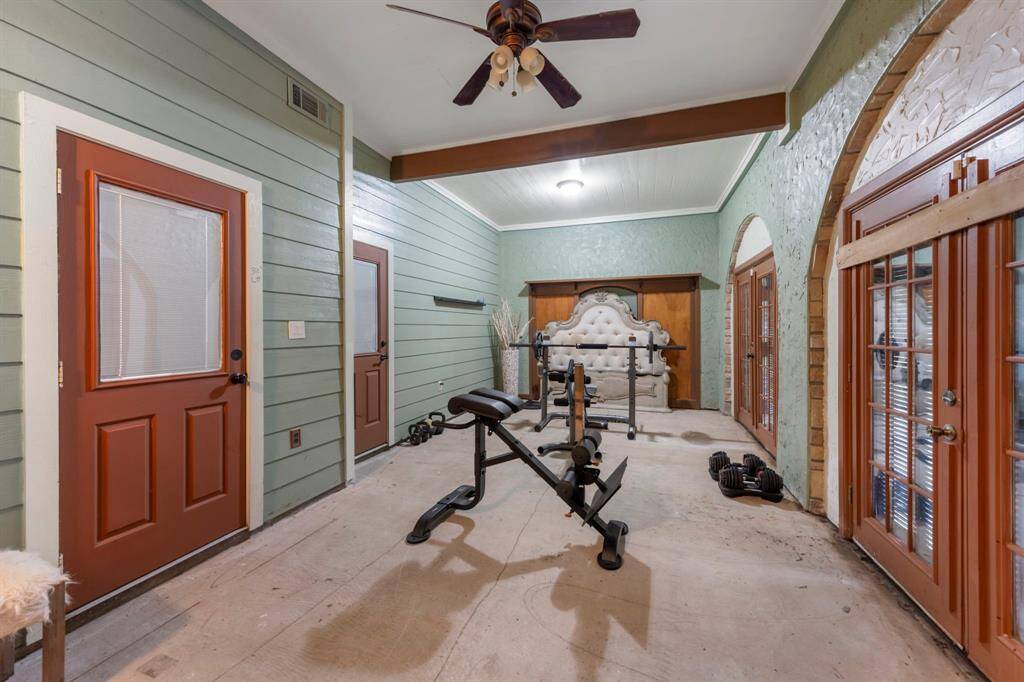 Versatile first-floor flex space with a bathroom, currently outfitted as a home gym—fitness equipment included.