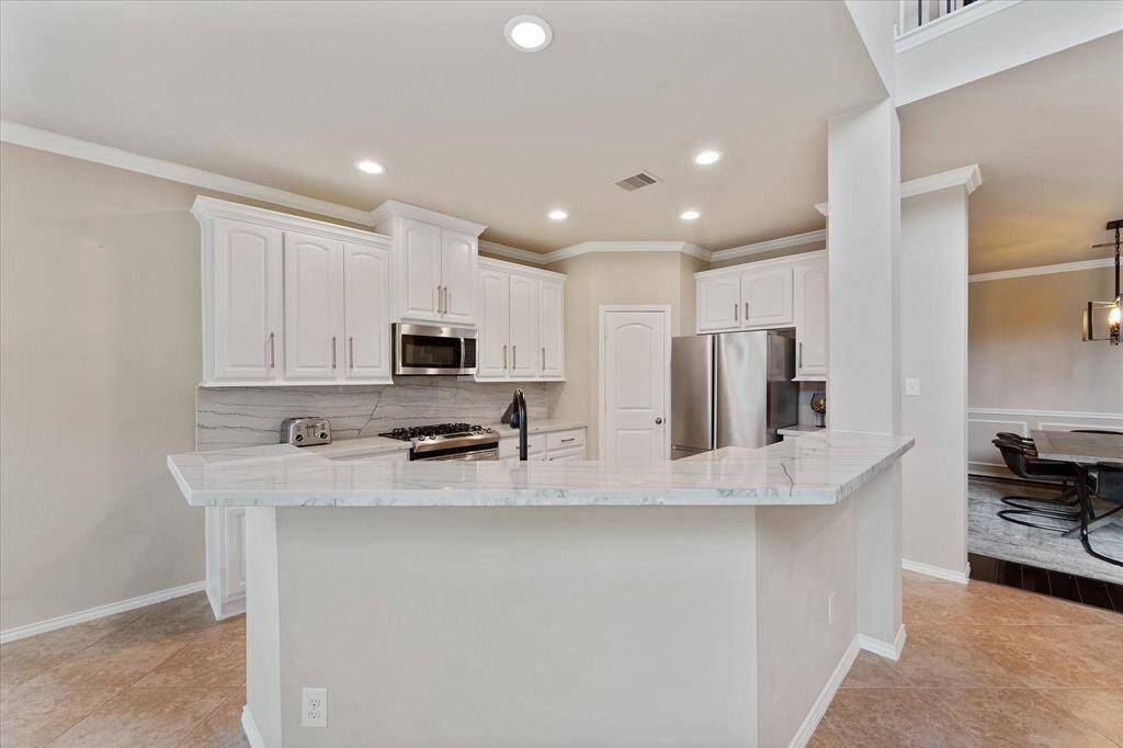 Cook's dream kitchen with white high/low cabinetry and stainless appliances