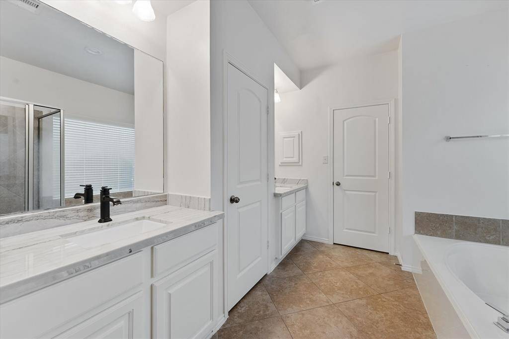 Primary ensuite with dual vanities, linen closet, soaking tub and separate shower