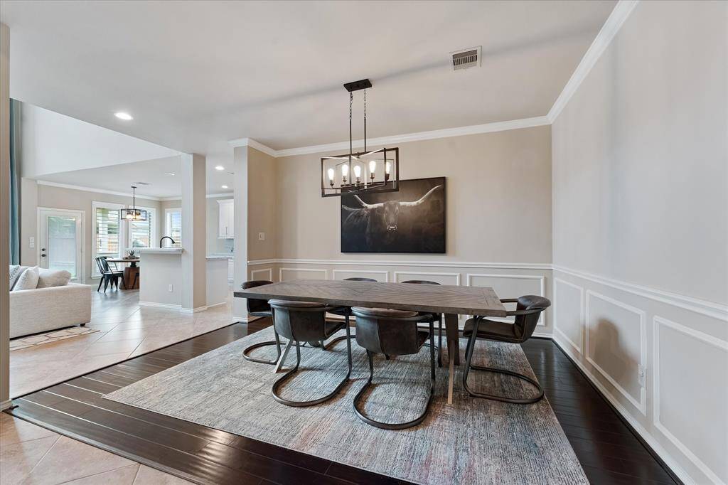Formal dining room with custom moldings and wood floors open to the living, kitchen and breakfast