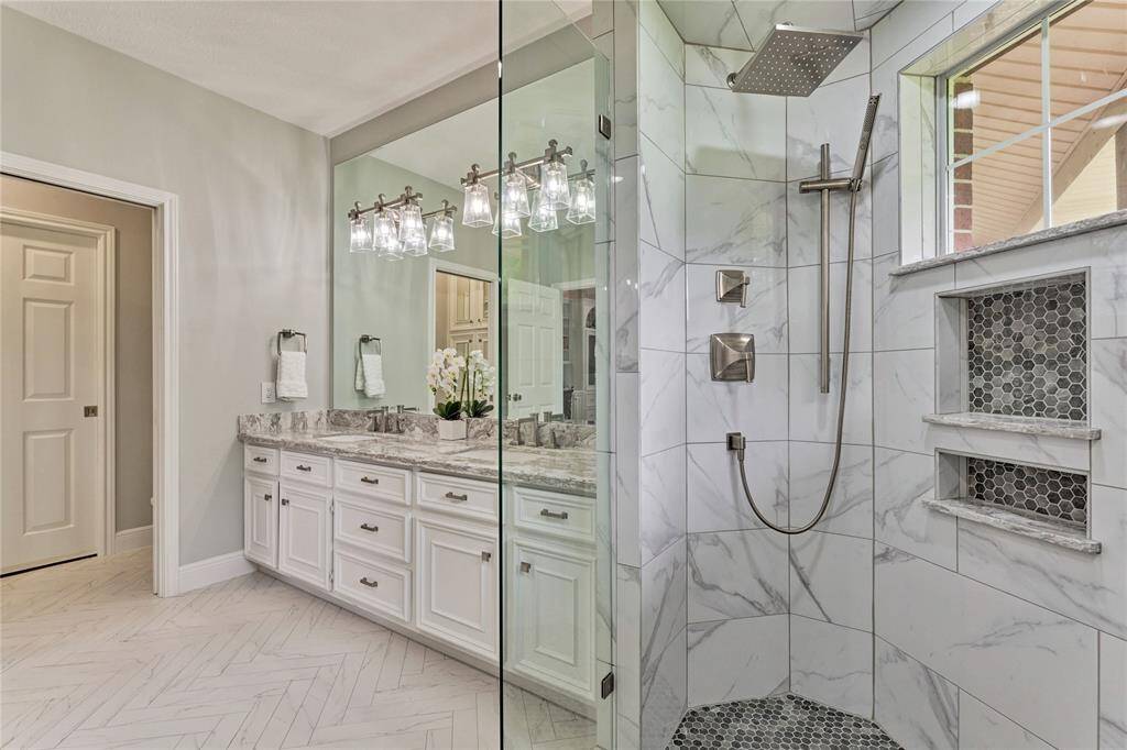Completely remodeled bathroom with herringbone tile, quartz counters and full glass shower