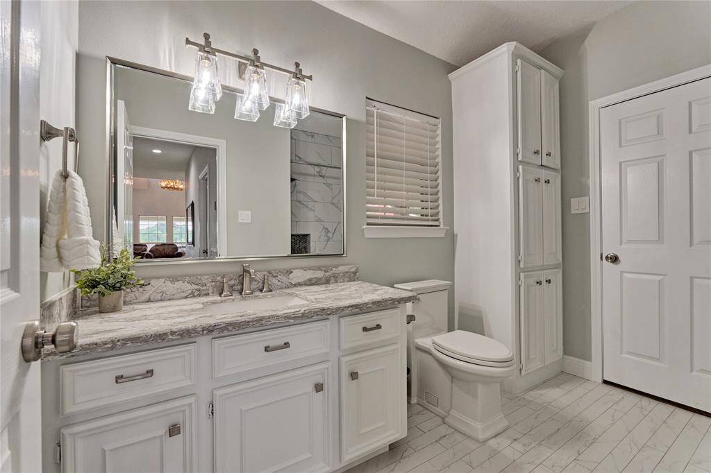 Completely remodeled bathroom with extra-wide tile, quartz counters and peaceful window views
