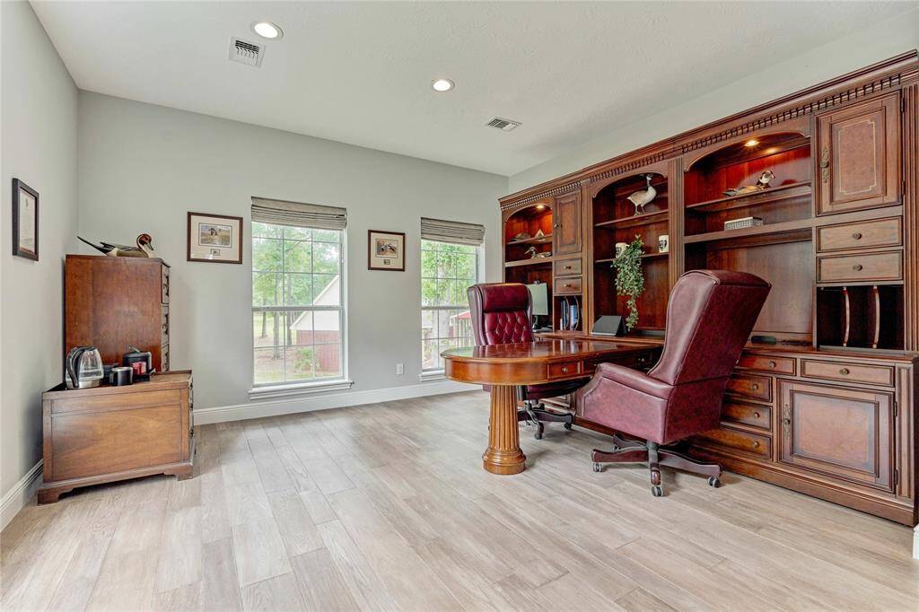 Large office with extensive natural light and LVP flooring, with sound proof walls for quiet study and work
