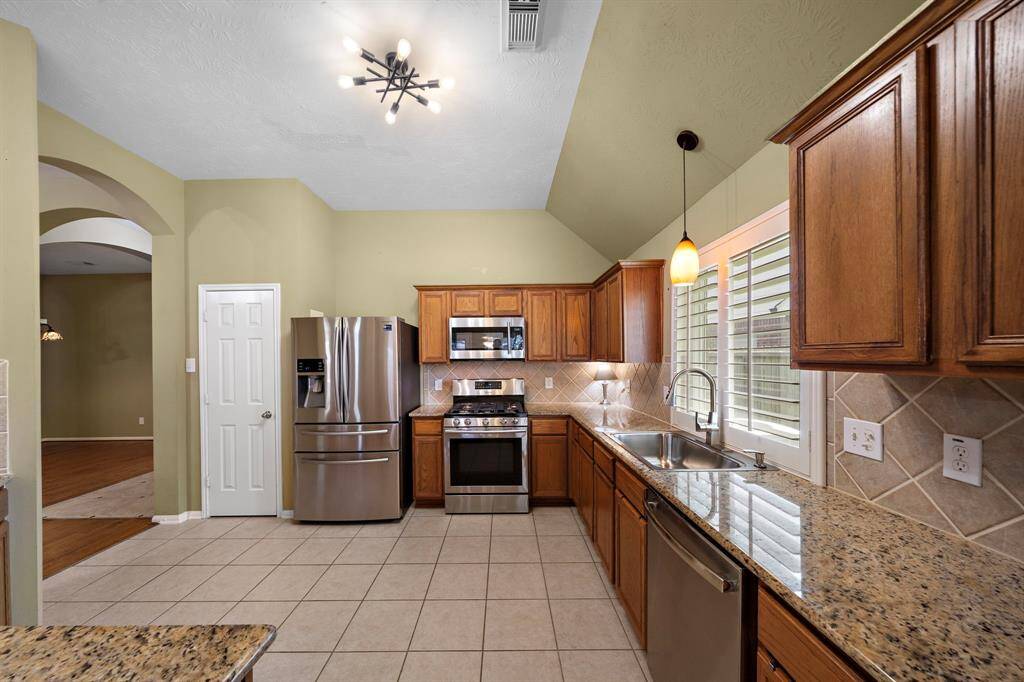 The kitchen features granite countertops and upgraded stainless steel appliances.