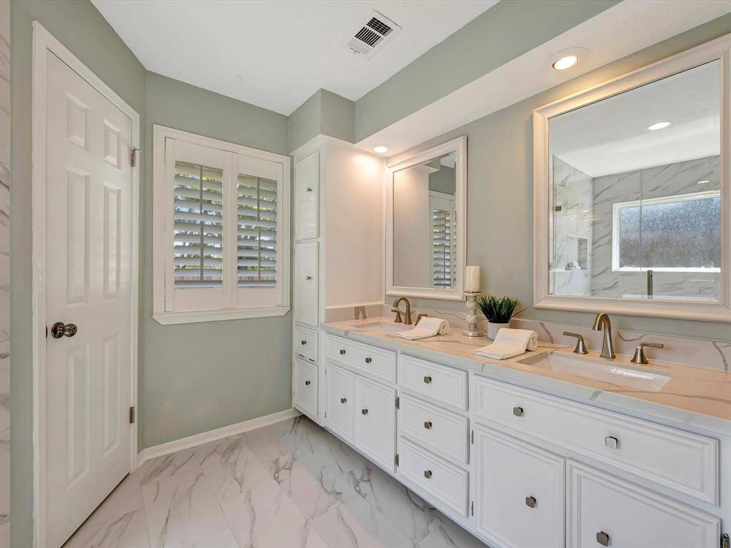 Primary bathroom with double sinks, quartz countertops and new faucets.