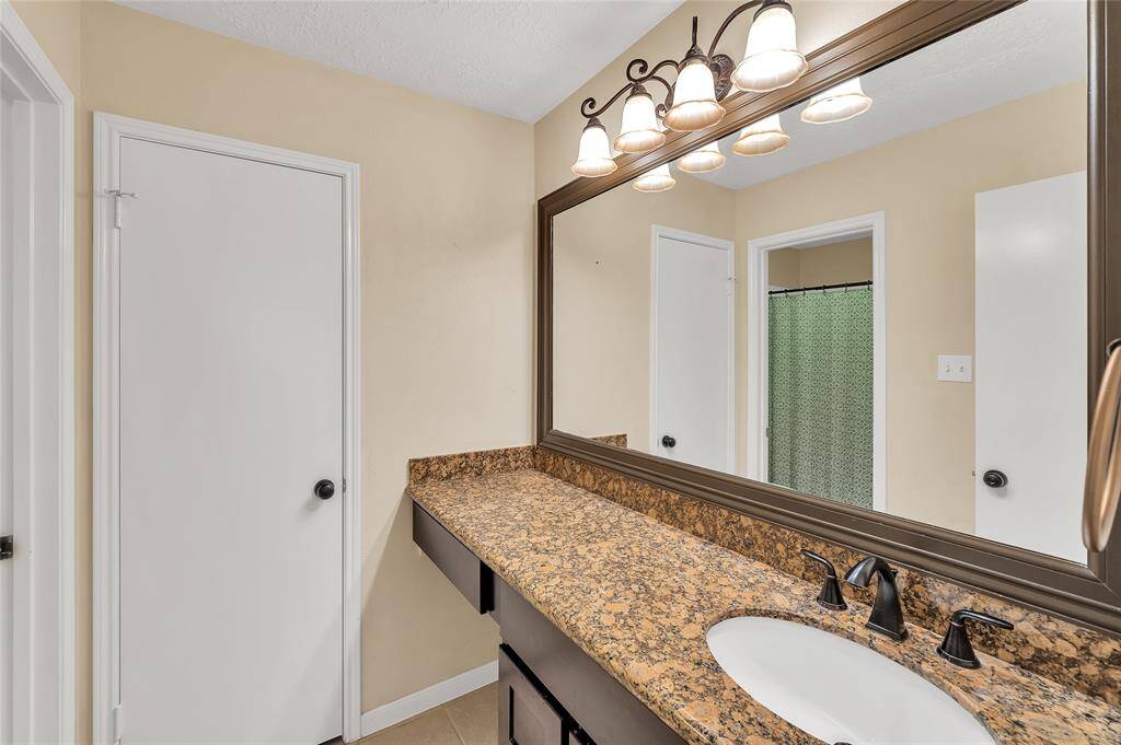 Secondary bath with vanity area, granite counters and linen closet.