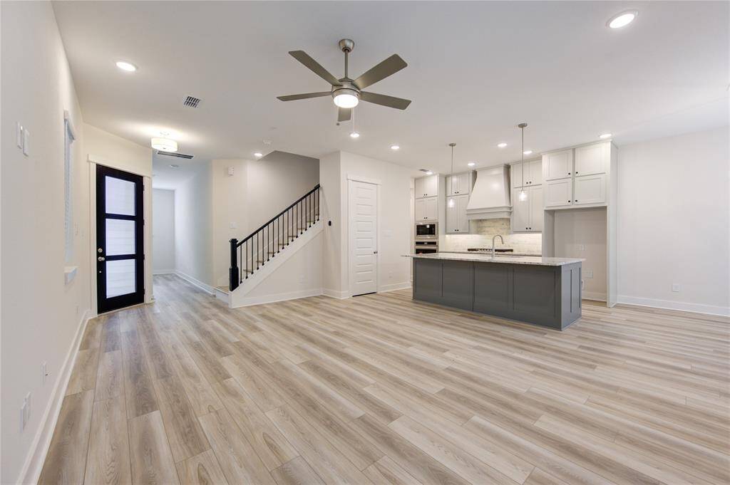 The living room, with its large windows and inviting ambiance, flows effortlessly into the chef's kitchen, allowing for easy interaction whether you're entertaining guests or spending quality time with family.