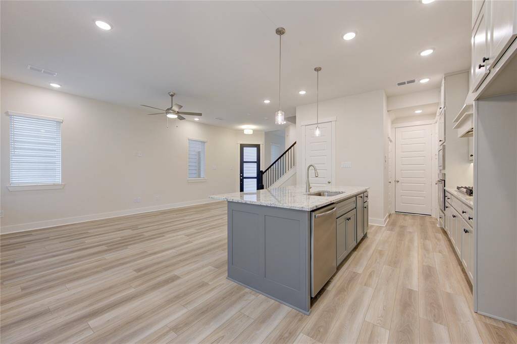 With contemporary lighting fixtures and elegant details, this kitchen offers a sophisticated yet inviting space for entertaining or everyday use.