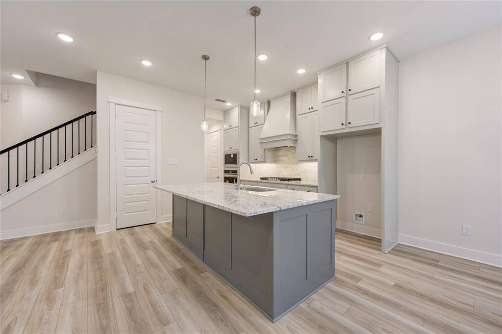 This brand new kitchen is the heart of the home, featuring sleek countertops, modern cabinetry, stainless steel appliances, and a large central island. It's designed for both style and function, with ample space for meal preparation and open sight lines to the adjoining living areas.
