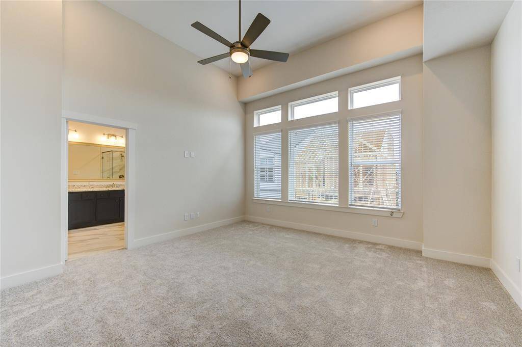 The private and spacious primary bedroom offers a serene retreat with natural light streaming through large windows and ample closet space. The neutral décor and generous layout create a perfect environment for rest and relaxation.