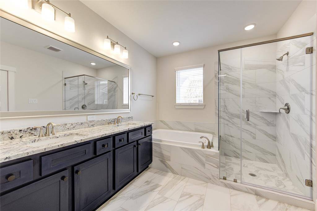 The en-suite primary bathroom features a double vanity, a soaking tub, and a separate walk-in shower. Designed with modern finishes and elegant tile work, this spa-like retreat also includes a large walk-in closet for added convenience.