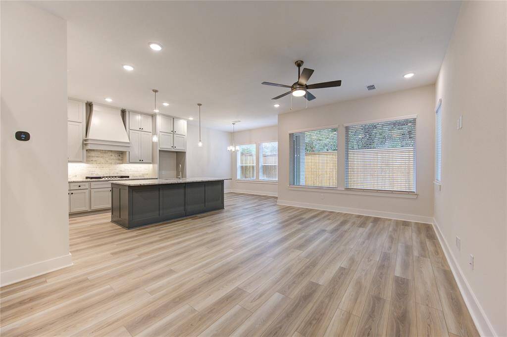 With its expansive layout, the family room includes custom recessed lighting, luxury vinyl plank flooring, and a neutral color palette, offering a stylish yet versatile space for daily living.