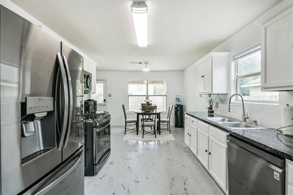 With its seamless flow from kitchen to breakfast nook and large windows overlooking the backyard, this space is as practical as it is welcoming. Stainless steel appliances, dark countertops, and bright white cabinetry make it both stylish and functional—the heart of the home.