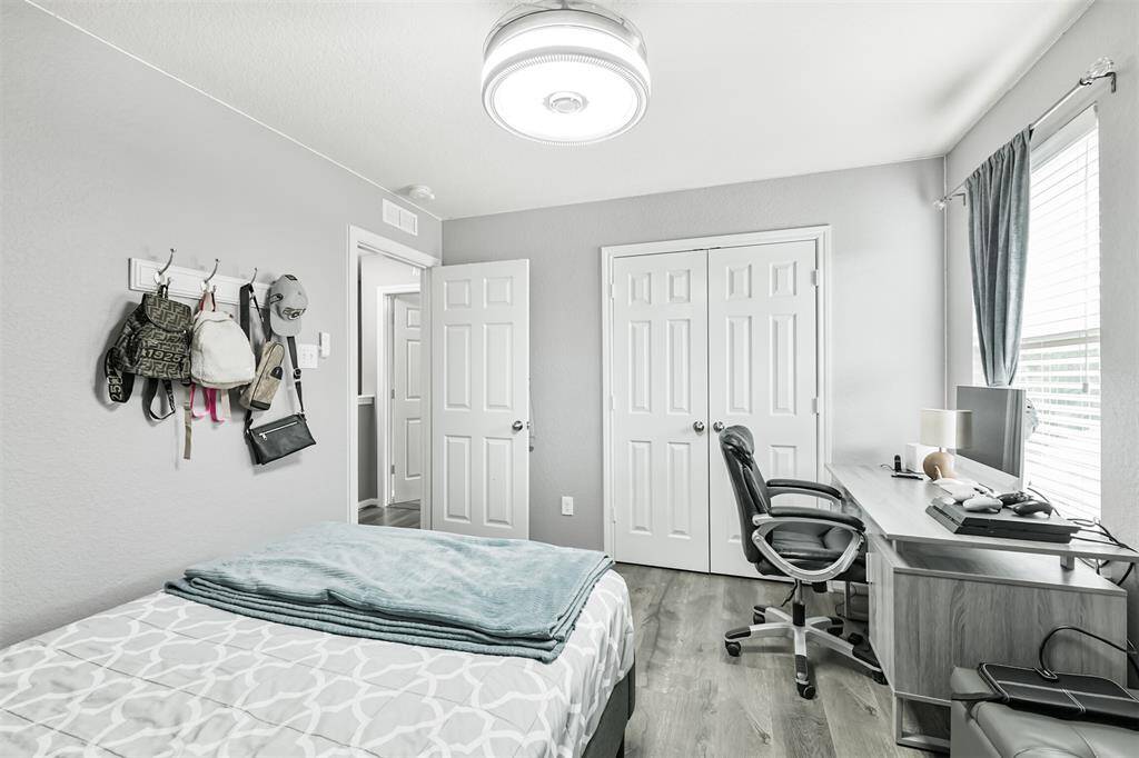This secondary bedroom offers great storage with a roomy double-door closet, plus space for a desk or vanity setup. Clean finishes, updated flooring, and natural light make it a comfortable and functional retreat.