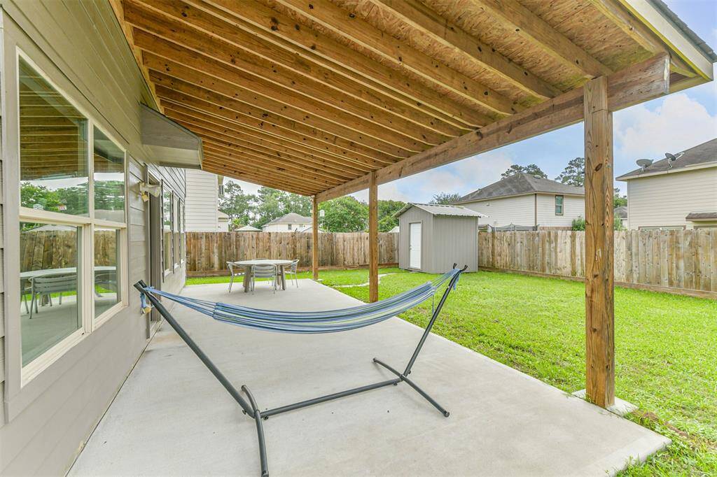 This extended covered patio offers ample room for outdoor furniture, dining, and entertaining. Overlooking a fully fenced backyard with a storage shed, it's the perfect setting to enjoy fresh air and quiet evenings.