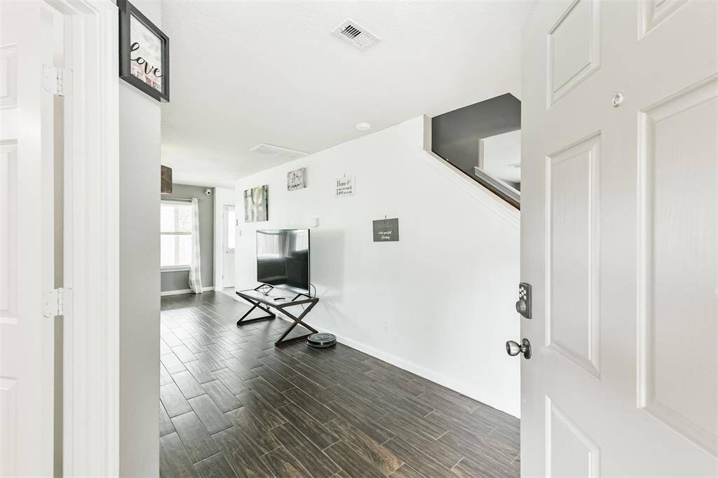 Step inside and feel instantly at home. This bright entryway opens to spacious living areas with rich wood-look tile flooring, clean lines, and an inviting open layout—perfect for welcoming guests or enjoying quiet evenings in.