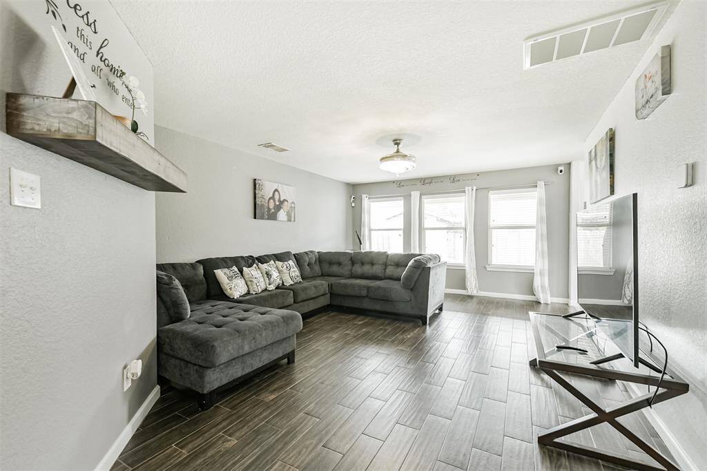Flooded with natural light, this cozy and spacious living room is the perfect spot to relax or gather with loved ones. With stylish wood-look tile flooring and an open, airy layout, it’s a space that instantly feels like home.