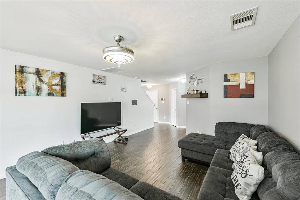 This view shows off the open flow from the living room to the entryway, creating a welcoming atmosphere from the moment you walk in. Thoughtful finishes like the contemporary light fixture adds a modern charm to the space.