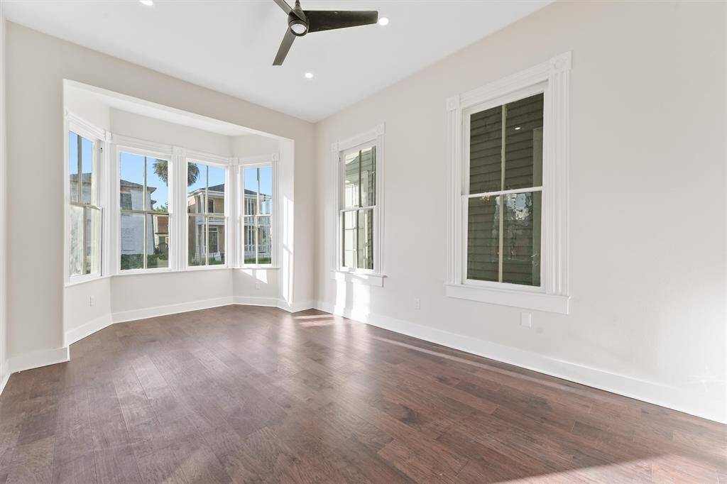 Open and airy living space with soaring ceilings, elegant millwork, and wide-plank engineered hardwood floors.