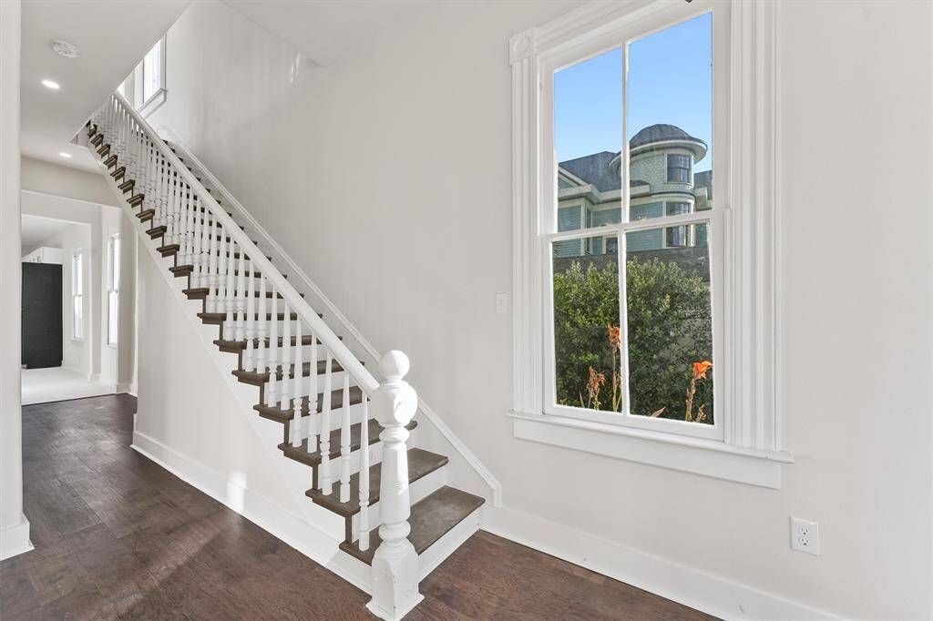 Classic banister detail and tall windows preserve the home's historical charm with modern finishes throughout.