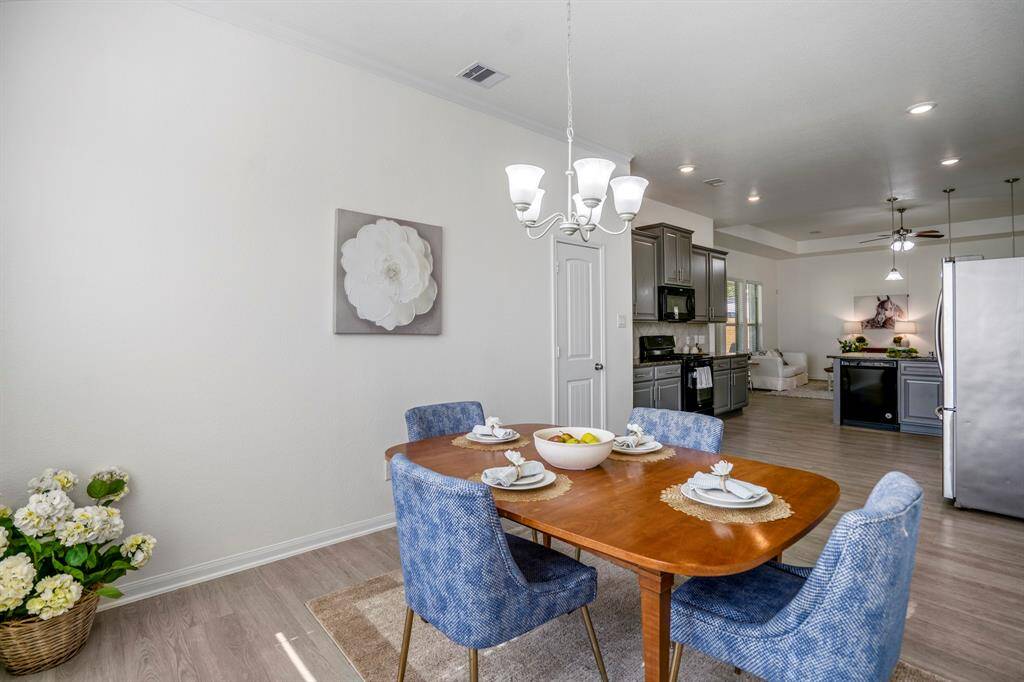 From the dining room, you have a clear view back into the kitchen, where the pantry door is conveniently located near the gas range, adding to the functional layout of the space.