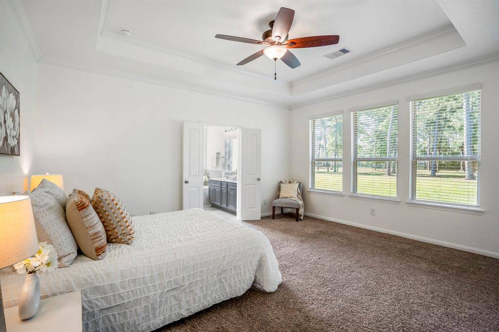 Entering the primary suite, you're greeted by a spacious room with a beautiful pop-up tray ceiling that adds an elegant touch. Large windows fill the space with natural light, creating a bright and airy retreat.