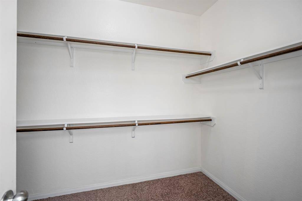 Step into the spacious walk-in closet, offering plenty of room for hanging clothes and organizing your wardrobe.