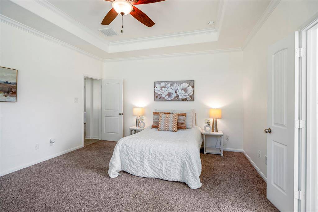 As we exit the primary bath, we get another view of the spacious primary bedroom, where the natural light continues to enhance the airy, open feel of the room.
