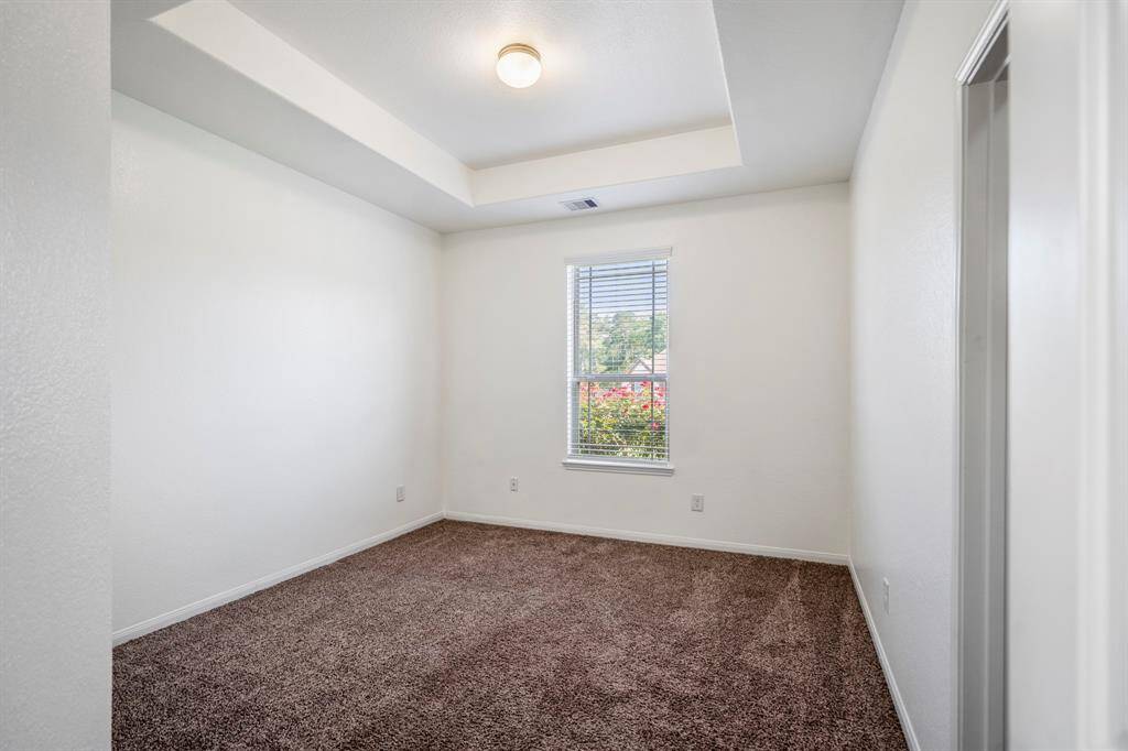 A peek into bedroom 3 reveals another pop-up ceiling detail and a large window that brings in plenty of natural light.