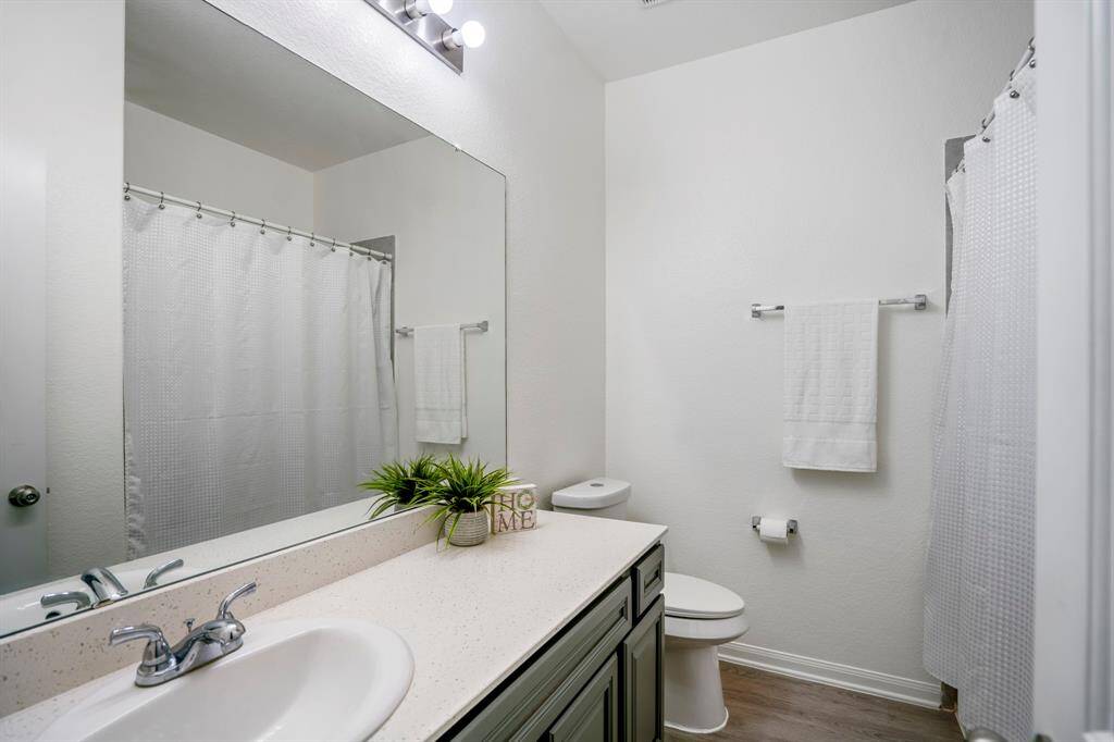 This full bathroom features a spacious vanity, neutral finishes, and a tub/shower combo conveniently located between the secondary bedrooms.