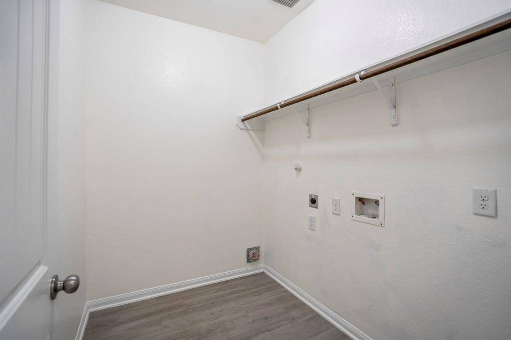 The laundry room offers plenty of space with easy access from the main hallway.