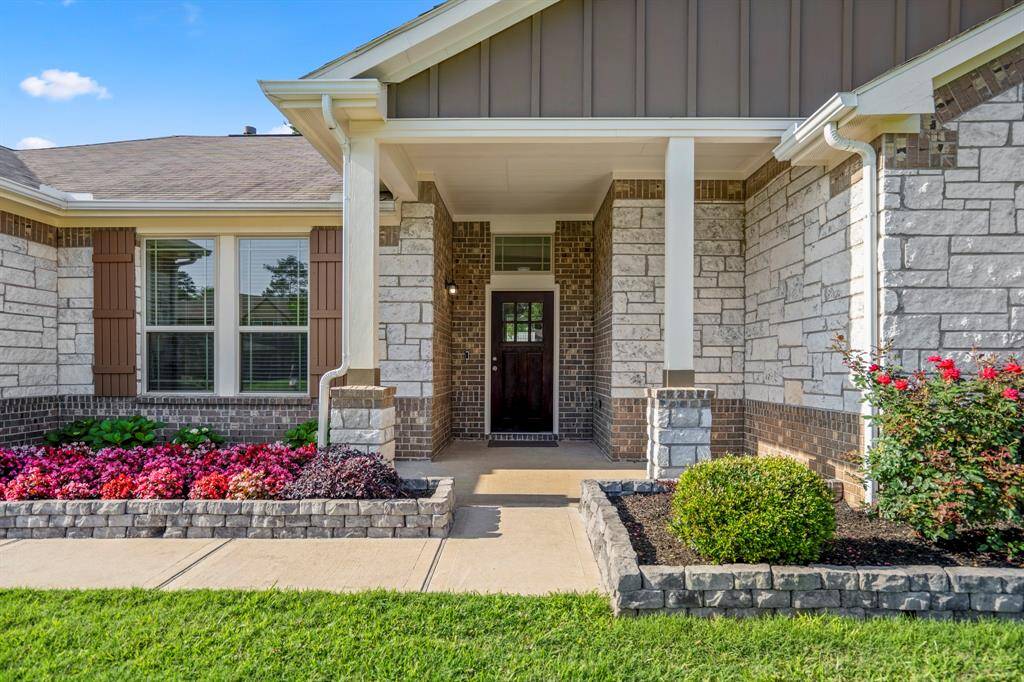 Charming front porch welcomes you home with a peaceful view of the spacious front yard.