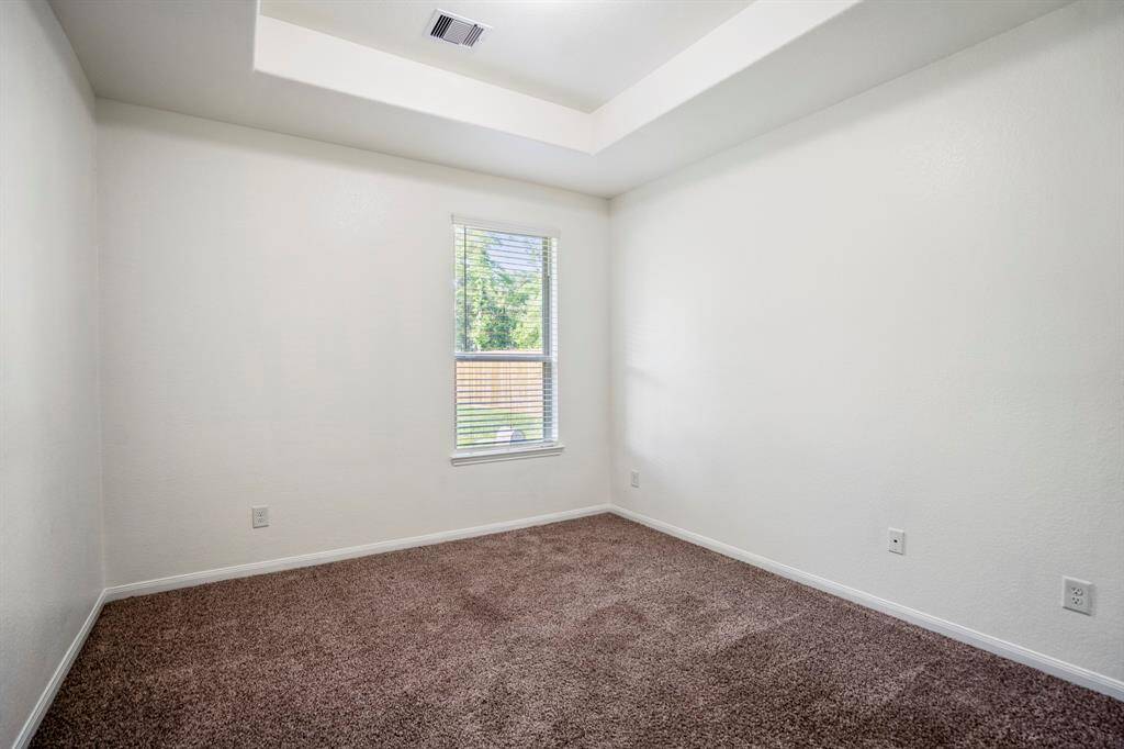 Bedroom 4 features a pop-up ceiling and a window that frames views of the backyard, bringing in soft natural light.