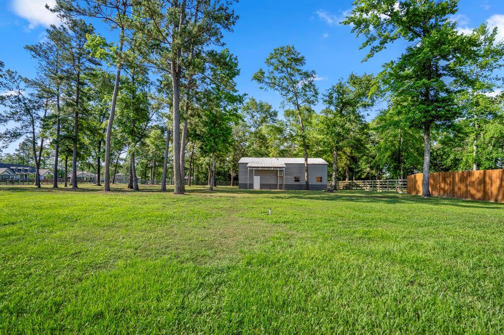 Looking out into the yard, the 30x40 metal barn stands out with its spray foam insulation and concrete slab floor, offering endless possibilities for storage, a workshop, or hobbies. The spacious yard is beautifully framed by mature trees, providing both privacy and a peaceful, country setting.