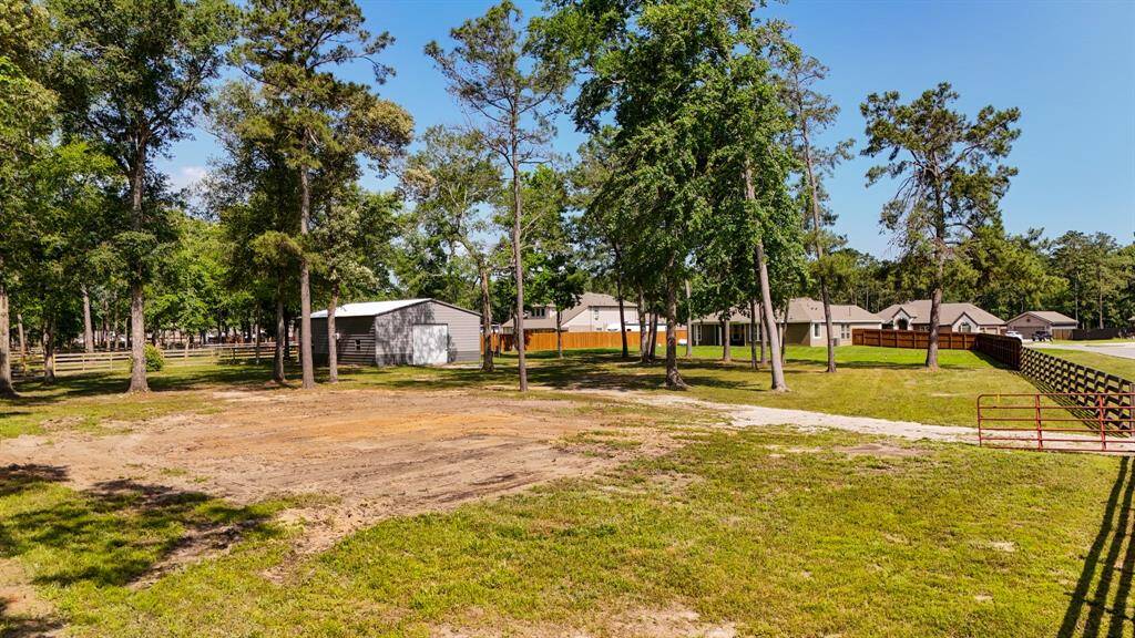 This view of the yard shows the ranch-style gate area, providing easy access to the property while maintaining a sense of privacy and seclusion in this spacious, tranquil setting.