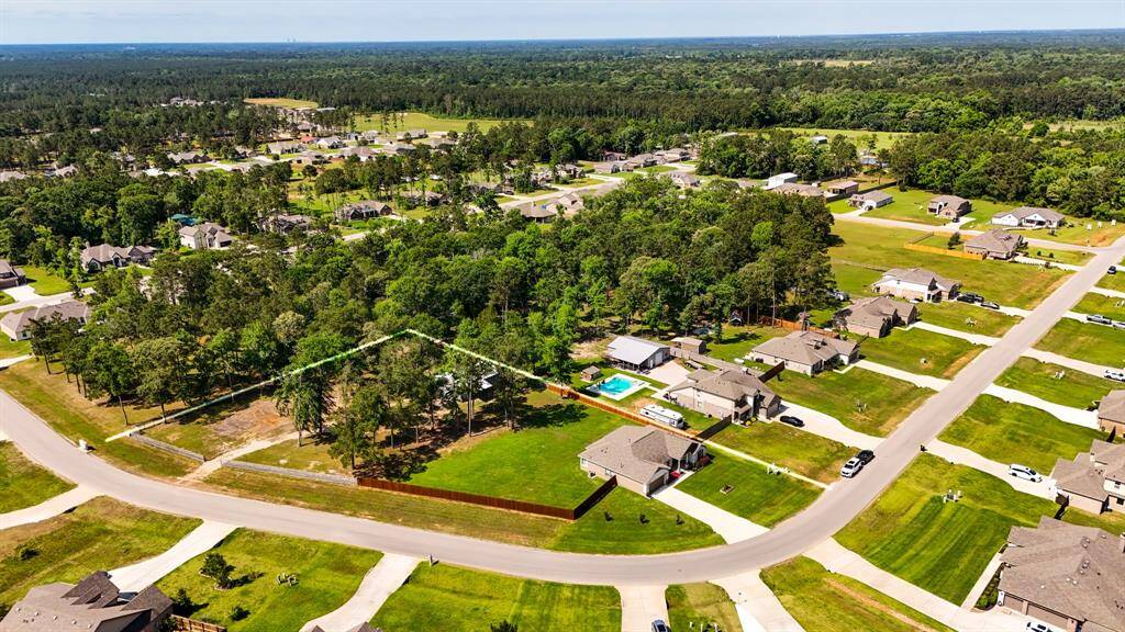 A wider aerial view from the same angle offers even more perspective on the size of the lot, the tree-lined yard, and the overall layout of the home and surrounding space.