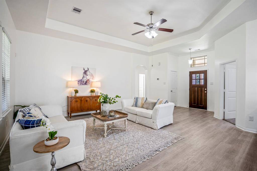 As we move closer to the kitchen, turning back to glance across the living room, we catch a view of the hallway leading to the secondary bedrooms, offering convenient access while maintaining privacy.