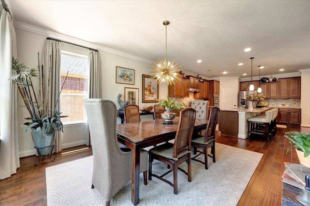 This elegant dining area is bathed in natural light, featuring a statement-making modern chandelier.