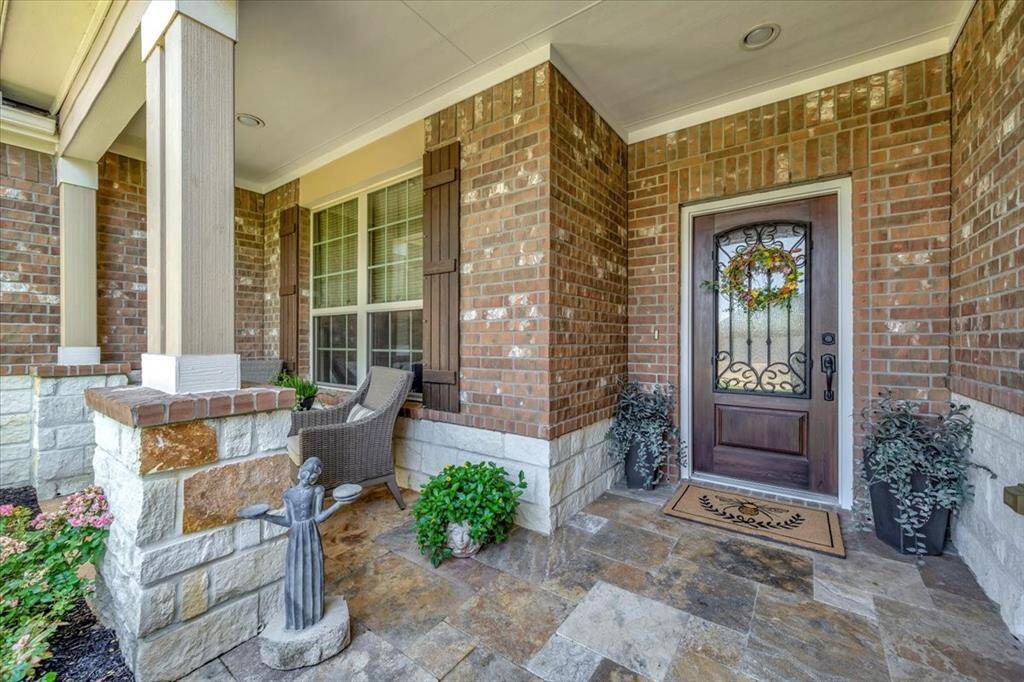 Inviting front porch with travertine tile – the perfect spot to enjoy a morning coffee or evening breeze