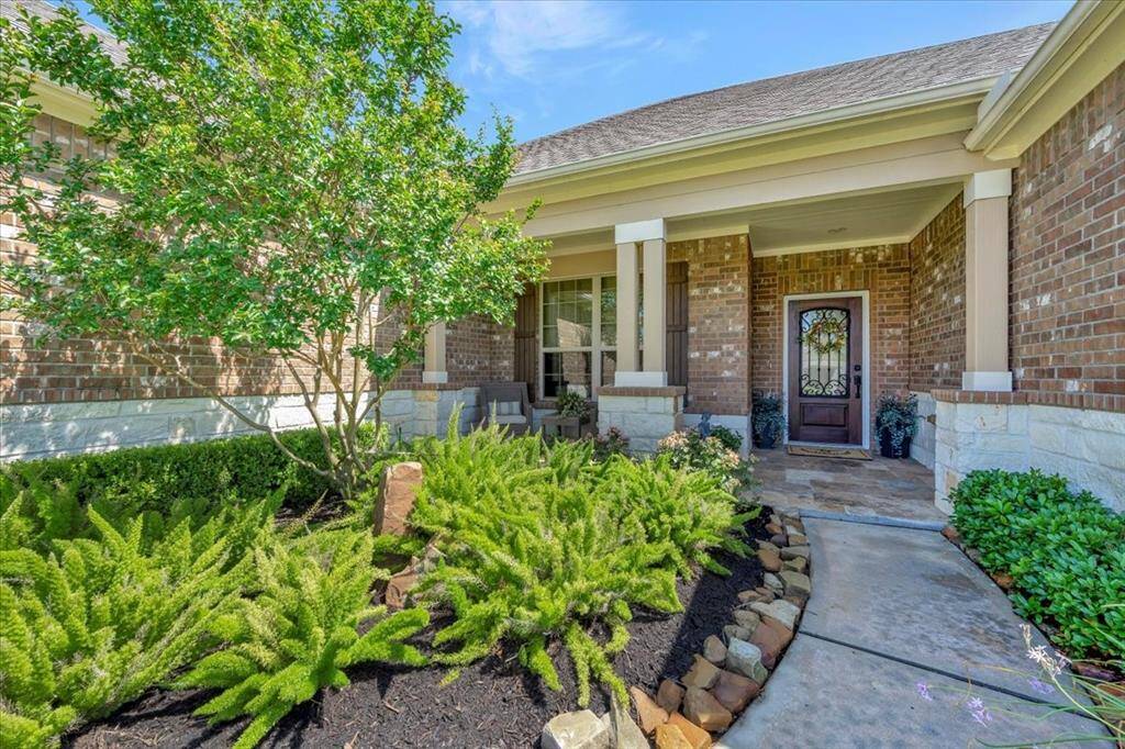 Gorgeous, professionally landscaped front yard – lush greenery, mature plants, and carefully manicured beds create a picture-perfect first impression.
