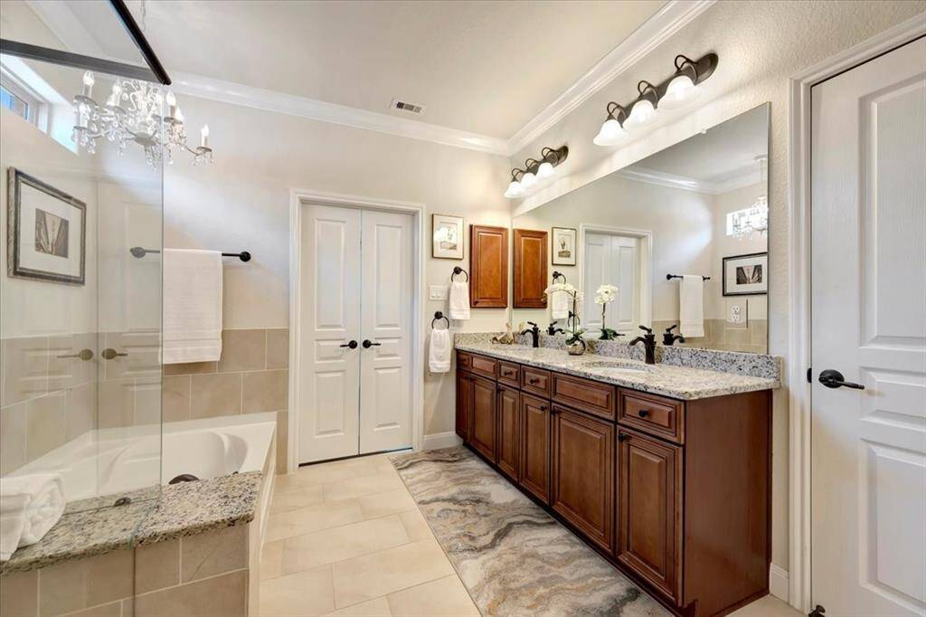 The ensuite bath offers dual vanities, separate shower, and a generous walk-in closet.