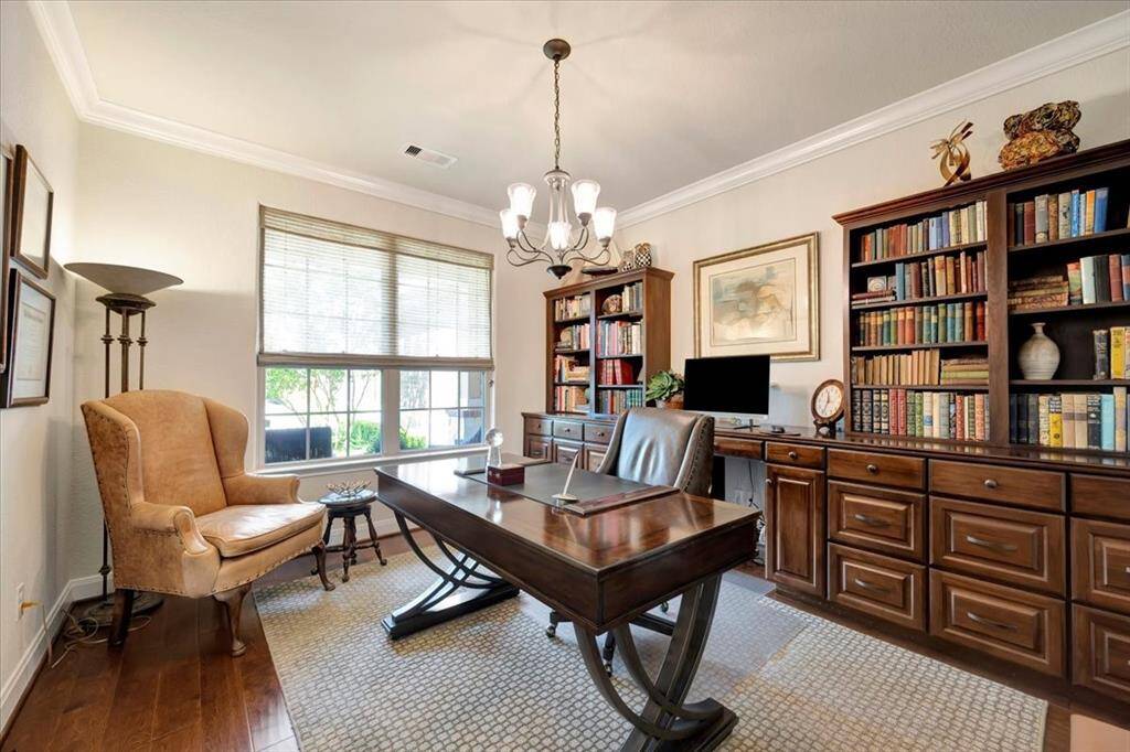 Sophisticated home office with elegant French doors, rich crown molding, and stunning custom built-in cabinetry and bookshelves
