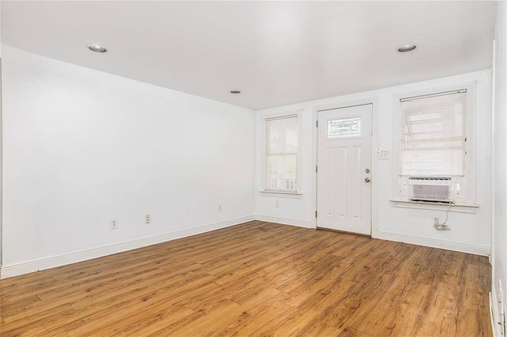Inviting downstairs living area in a bright duplex, featuring sleek flooring and ample natural light.