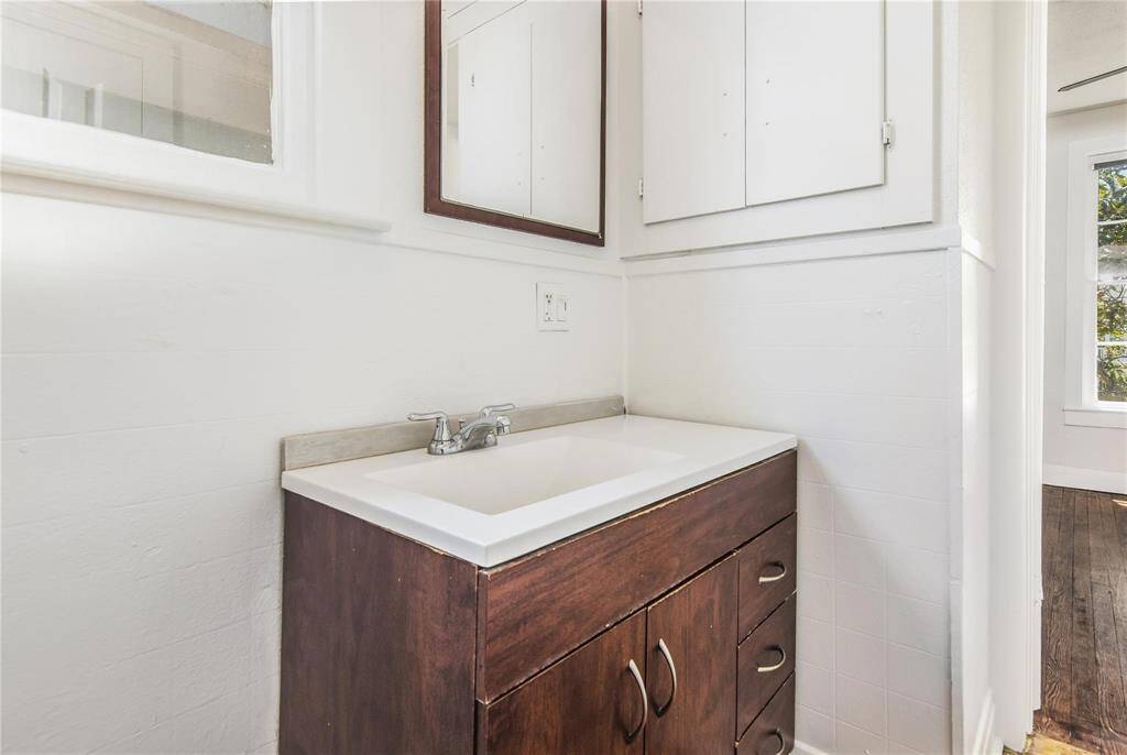 Charming upstairs bathroom in the duplex, featuring modern fixtures and abundant natural light.