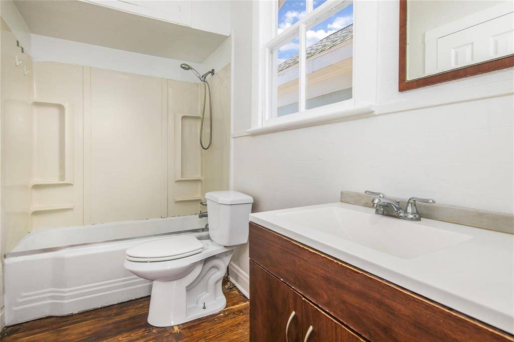 Bright and inviting upper duplex bathroom featuring a modern vanity, spacious shower-tub combo, and ample natural light.