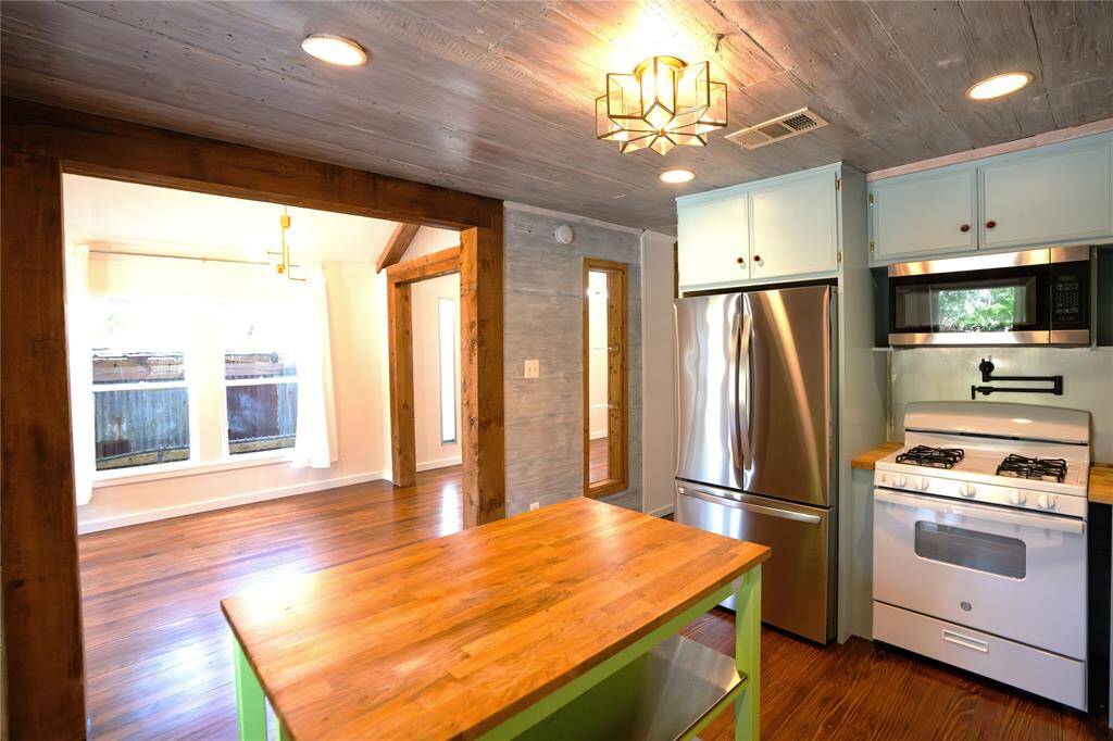 Island with butcher block countertop with open shelving.