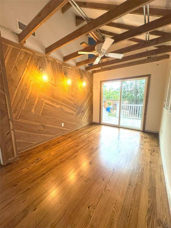 The Primary bedroom with wood accent wall and wood beams.